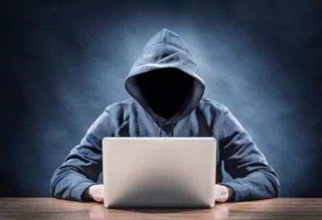 Website Pflege und Website Betreuung verhindert dass Hacker Ihre Homepage übernehmen. Anonymer Hacker am Notebook